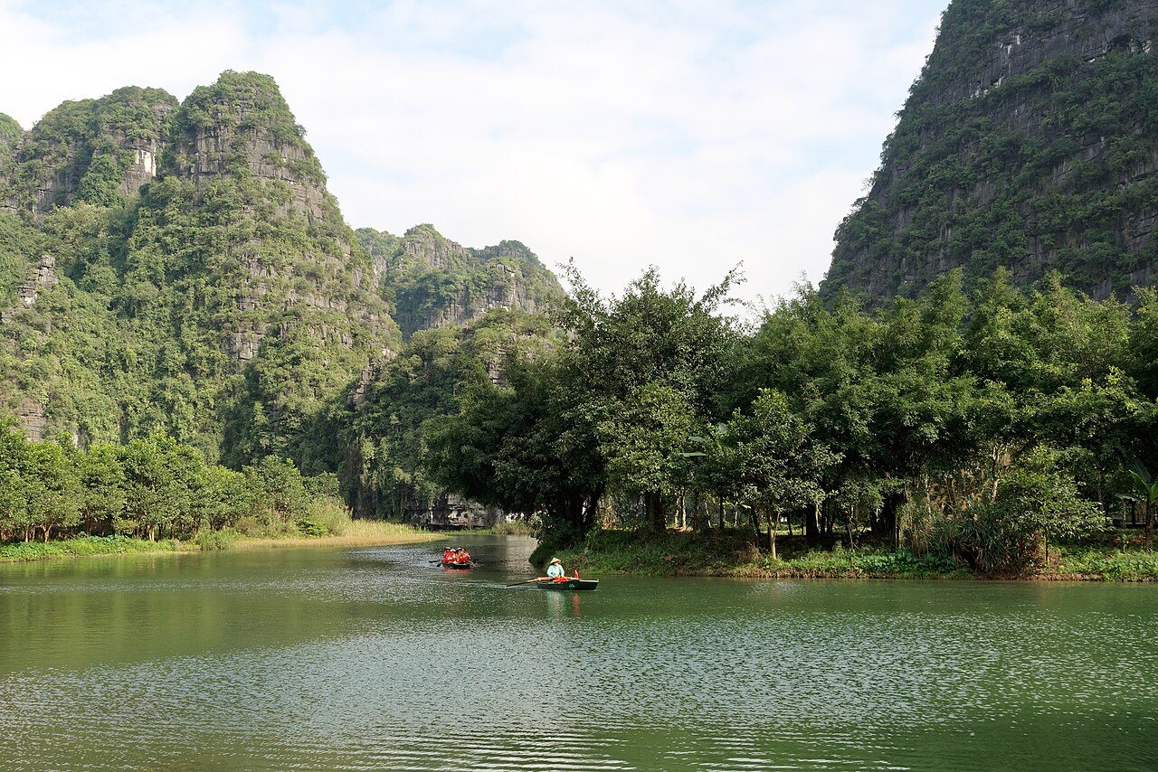 Embarcaciones y montañas junto al agua en Tràng An, Vietnam.